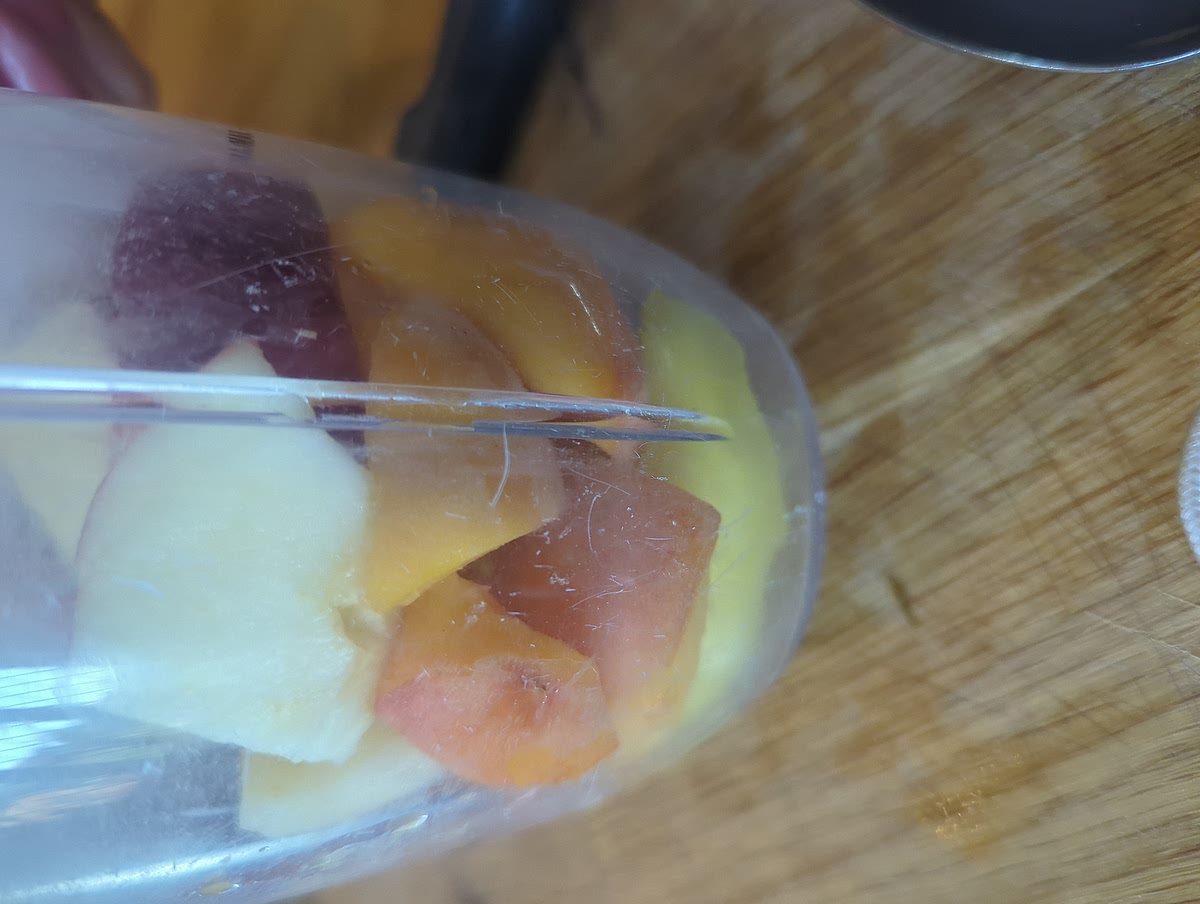 Cut up mango, apple and peach and add to blender