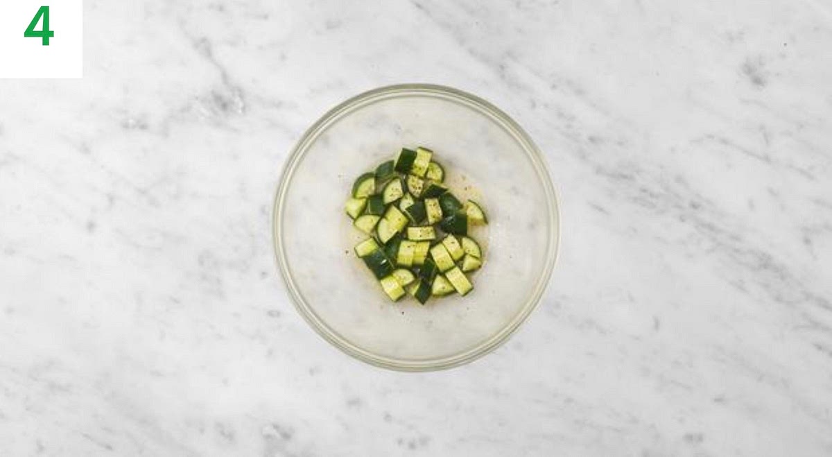 Meanwhile, trim the cucumber then cut into small 1cm pieces.
Add the cucumber to a large bowl with the cider vinegar, sugar and olive oil for the dressing.
Season with salt and pepper then toss to combine.