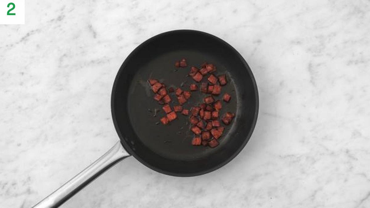 Meanwhile, heat a frying pan on medium-high heat (no oil).
Fry the chorizo, 3-4 mins.
Thinly slice the chilli.