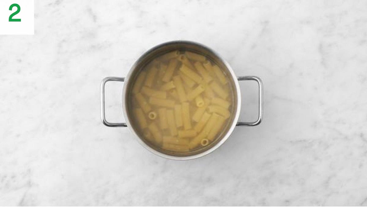 Once boiling, add the rigatoni to the water and bring back to the boil. Cook until tender 12 mins.
When ready, reserve some of the pasta water, then drain in a colander.
Pop the pasta back into the pan, drizzle with oil and stir through to stop it sticking together.
