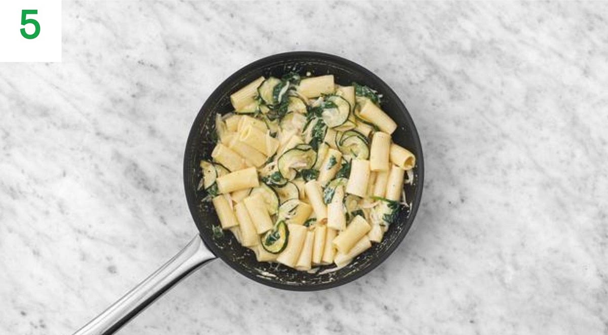 Stir three quarters of the hard italian style cheese through your creamy sauce.
Add the cooked pasta and the cooked green veg and stir well to combine. Simmer until everything/s piping hot, 1-2 mins.
Add a pinch of lemon zest and squeeze of lemon juice.
Taste and add more salt, pepper and lemon juice if needed. Add a splash of water if it’s a little too thick.