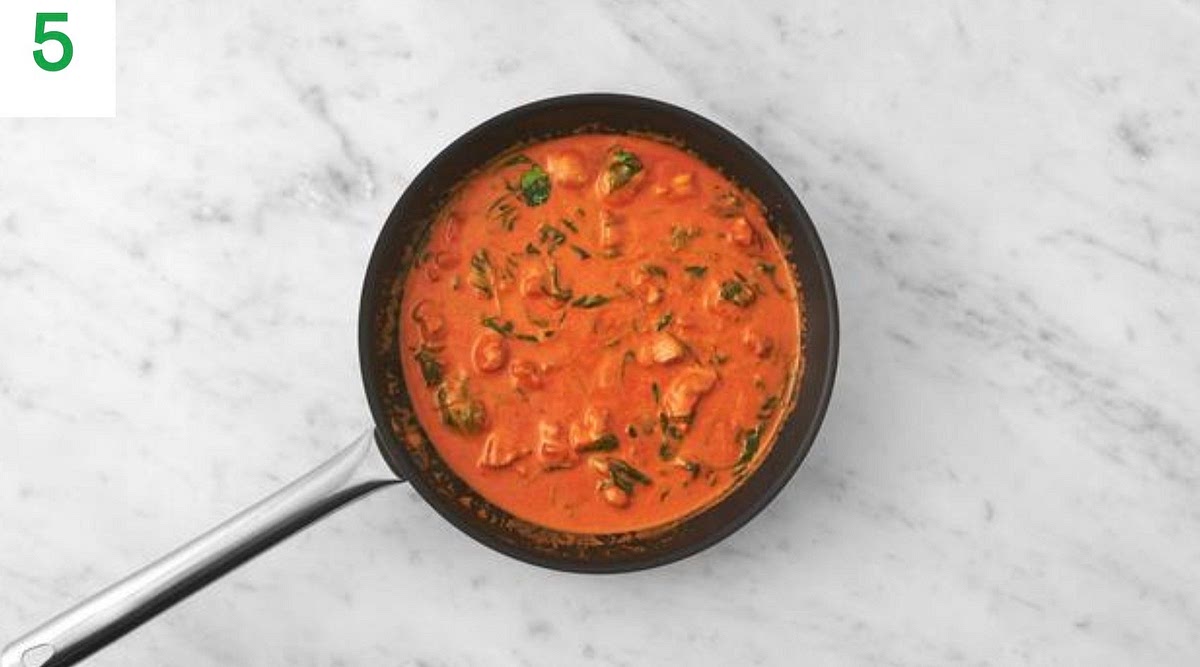 Once the sauce has thickened, stir through two thirds of the hard italian style cheese, followed by the crème fraiche.
Add the spinach to the pan a handful at a time until wilted and piping hot, 1-2 mins.
Bring the sauce to the boil, stirring, then remove from the heat.
Taste and season with salt and pepper if needed.