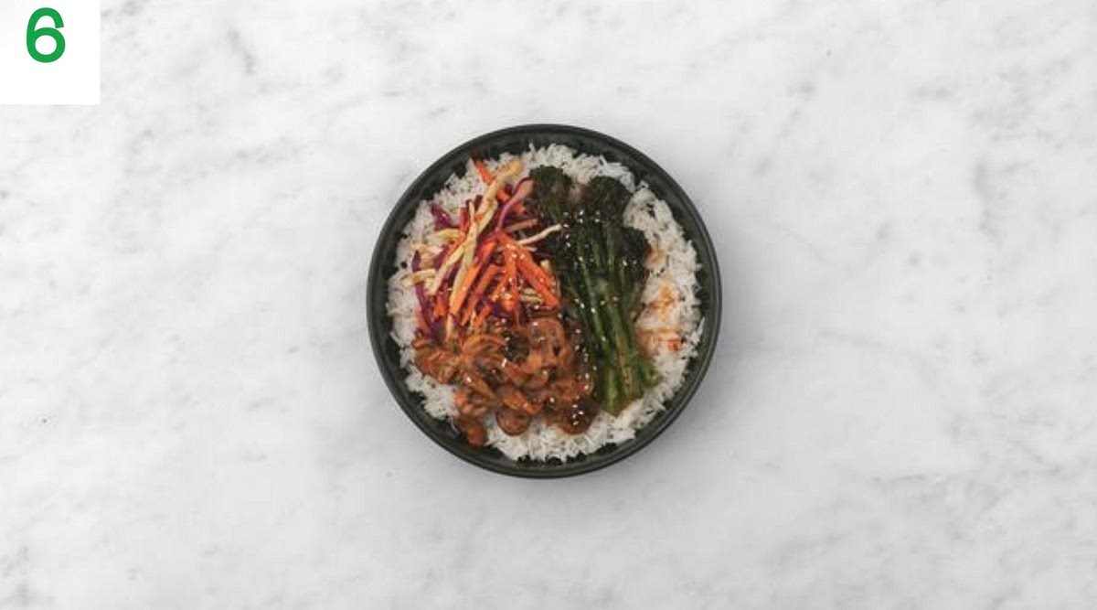 When eerything’s ready, share the rice between your bowls.
Top with the creamy Gochujang mushrooms, kimchi style slaw and roasted broccoli in separate sections.
Drizzle the sweet chilli sauce over the broccoli and sprinkle over the sesame seeds to finish.