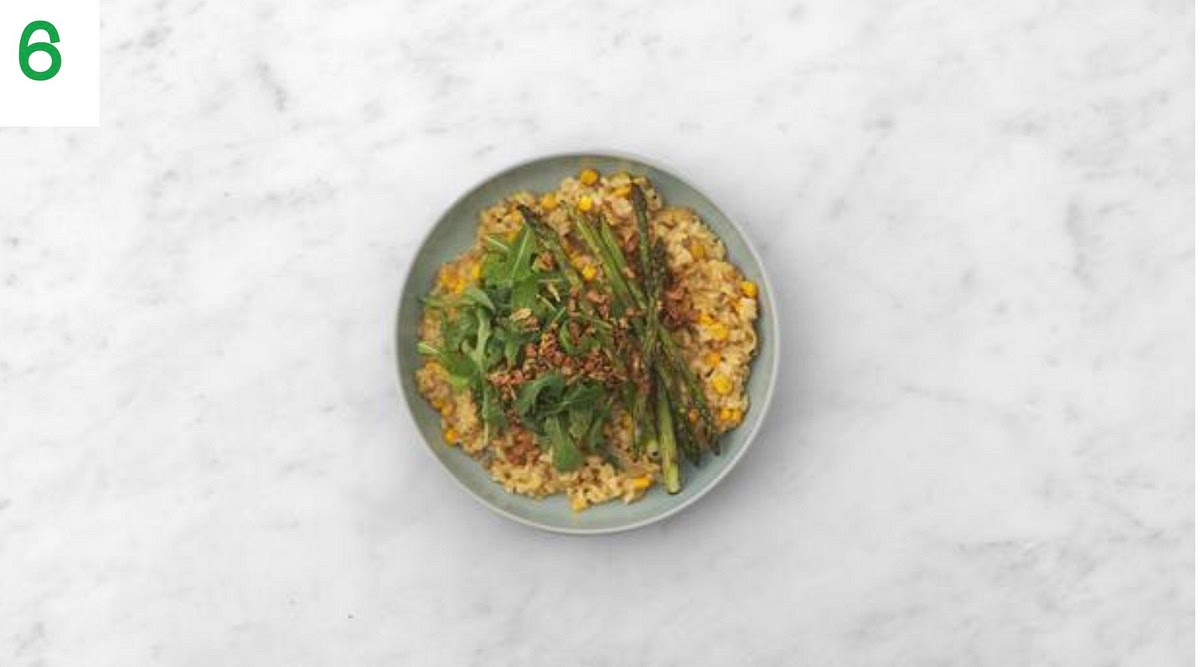 When you’re ready to serve, add the rocket to the bowl of dressing and toss to coat.
Share your risotto out between your bowls and top with the lemon-dressed rocket and roasted asparagus.
Sprinkle over the crispy onions to finish.