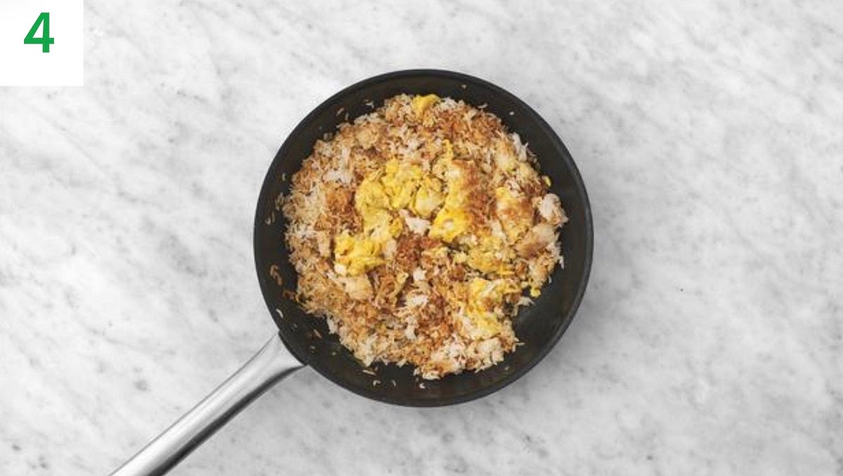 Once the rice is cooked, in a medium bowl, whisk the egg (see pantry for amount) until combined and season with a pinch of salt and pepper.
Heat a drizzle of oil in a frying pan on medium-high heat.
Pour the egg into the frying pan and cook for 30 secs without stirring, then gently stir to break it up, making sure the egg doesn't stick to the bottom of the pan, 2-3mins. IMPORTANT: Ensure egg whites are fully cooked.
Once cooked, add the rice to the egg along with a third of the soy sauce and stir together. Remove from the heat and set the pan aside.