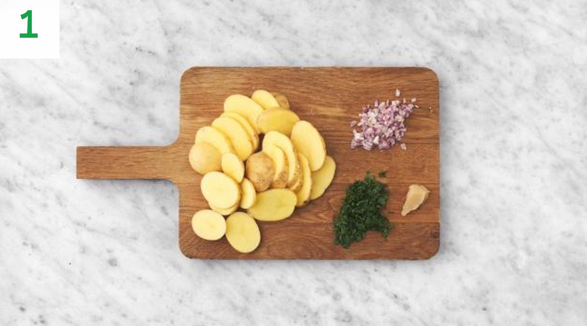 Preheat your oven to 220°C/200°C fan/gas mark 7.
Remove the lamb steaks from your fridge to allow them to come up to room temperature.
Bring a large saucepan of water with ½ tsp salt to the boil for the potatoes.
Peel and slice the potatoes into 1cm thick rounds.
Halve, peel and chop the shallot into small pieces.
Roughly chop the parsley (stalks and all). Peel and grate the garlic (or use a garlic press).