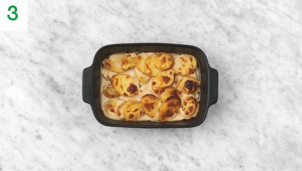 Next, heat a drizzle of oil in a large frying pan on medium heat. Once hot, add half the garlic and cook until fragrant, 30 secs. Add the creme fraiche, water for the dauphinoise (see pantry for amount), half the chicken stock paste and half the Italian style cheese.
Stir to combine, bring to the boil, then remove from the heat. Season to taste with salt and pepper.
Lay the cooked potato slices in layers in an appropriately sized ovenproof dish, then pour over the creamy sauce. Sprinkle the remaining cheese on top.
Bake on the top shelf of your oven until golden brown and bubbly, 15-20 mins. TIP: Put the dish onto a baking tray to catch any drips.