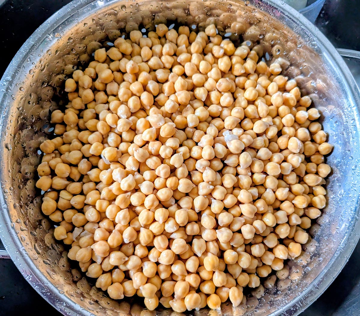 After soaking, the chickpeas would have grown in size and absorbed a good part of the water. Throw away the remaining water, rinse them well, and put them back in the pot. Put fresh water in, level should be 2-3 cm above the chickpea level and put them back in the pot, and bring the pot to a boil, then reduce heat to low, cover and let it simmer for about 1 hour. Check regularly while simmering, and skim out any foam that forms on top with a slotted spoon, as it can add a bitter taste if left in.