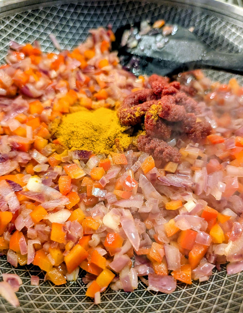 Add the tomato paste, paprika and turmeric, mix well and fry them for 1-2 minutes. Then turn off the heat and put the sofrito to the side.