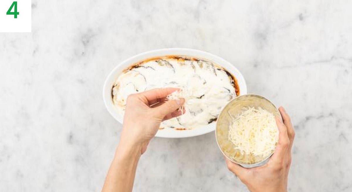 When the tomato lentil sauce is ready, stir through the butter (see pantry for amount) until melted, then transfer to an ovenproof dish. Layer over the aubergine slices.
Spread the creme fraiche out evenly on top, then sprinkle over the cheese. Season with pepper.
Halve the ciabatta. Spread over the remaining garlic, drizzle with oil and season with salt.