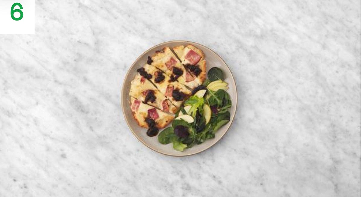 When the naanizzas are ready, remove from the oven and share between your plates.
Drizzle over the onion marmalade.
Serve the apple and baby leaf salad alongside.