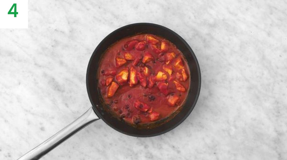 Pour in the passata, water for the sauce and the remaining chicken stock paste.
Stir in the cranberries and a pinch of sugar (if you'd like).
Stir and bring to the boil, then reduce the heat and simmer until thickened, 3-4 mins.