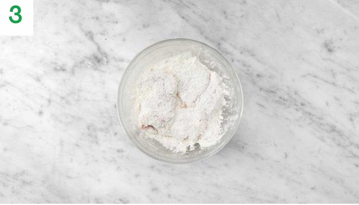 Meanwhile, put the cornflour into a large bowl and season with salt and pepper. Mix to combine.
Add the chicken thighs to the bowl and turn to coat in the cornflour.