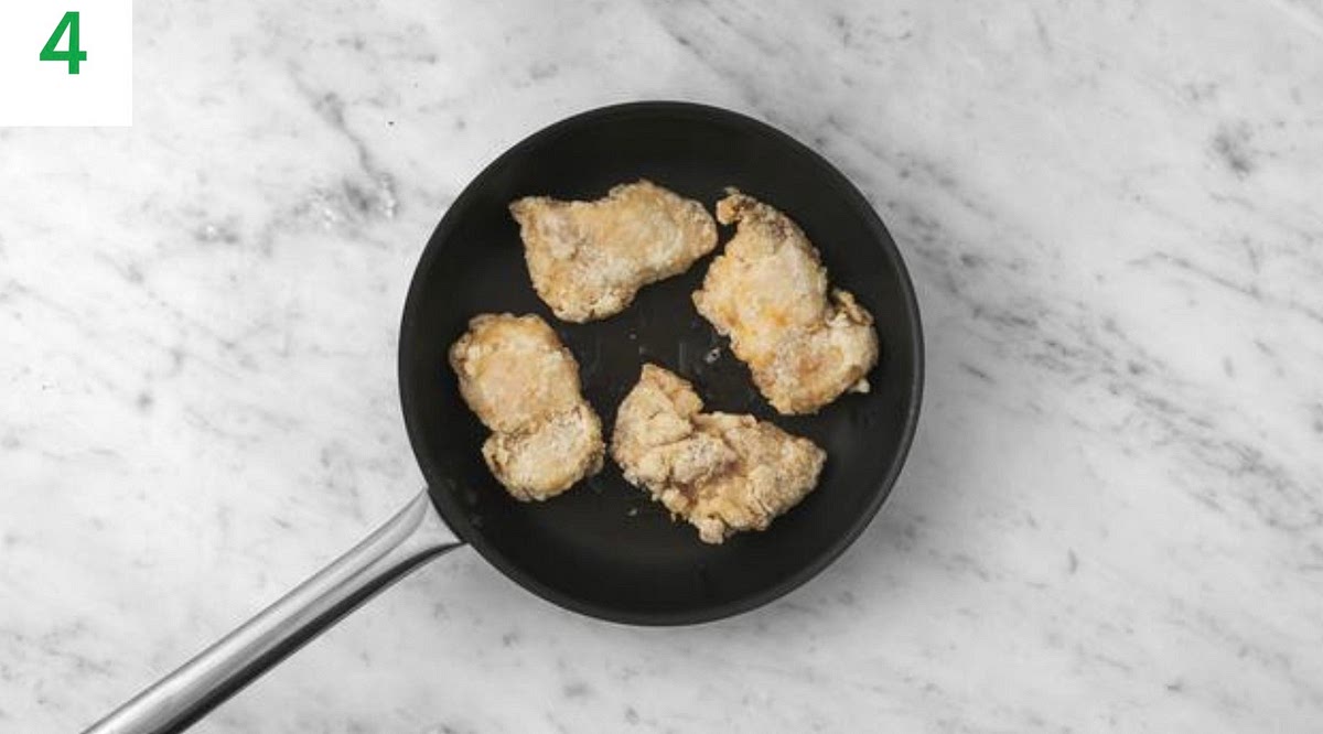 Put a large frying pan on high heat and add enough oil to completely coat the bottom of the pan. TIP: You want the oil to be hot so the chicken fries properly - heat for2-3 mins before you add the chicken. Once hot, carefully lay the chicken into the pan, reduce the heat to medium-high and fry until golden brown and cooked through, 12-14 mins total.
Turn every 2-3 mins and adjust the heat as necessary.
Discard any cornflour left in the bowl.  in the bowl.
Once cooked, remove from the heat and place the chicken onto a plate lined with kitchen paper. IMPORTANT: The chicken is cooked when no longer pink in the middle.