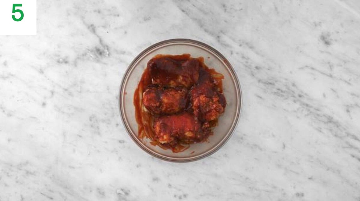 While the chicken is frying, in another medium bowl, combine the remaining gochujang with the remaining ginger puree, honey and ketchup. Season with salt and pepper. TIP: If your honey has hardened, put the sachet in a bowl of hot water for 1 min to loosen.
Once the chicken has cooked, transfer it to the bowl of sauce. Turn the chicken in the sauce until evenly coated.