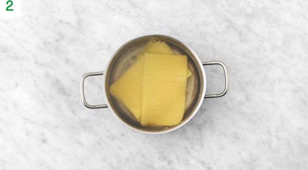 Meanwhile, break each lasagne sheet into roughly 5-6 pieces.
Pour the boiled water into a medium saucepan with ½ tsp salt on high heat.
Boil the lasagne sheets, 12 mins.
Once cooked, drain and pop back in the pan. Drizzle with oil.