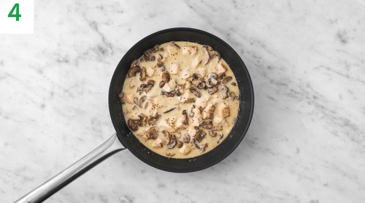 Once the chicken and mushrooms are cooked, add the garlic to the pan. Stir-fry for 1 min.
Pour in the chicken stock paste and water for the sauce (see pantry for amount), then bring to the boil and reduce by half, 2-3 mins.
Stir through the creme fraiche and mustard until everything's piping hot, 2-3 mins.