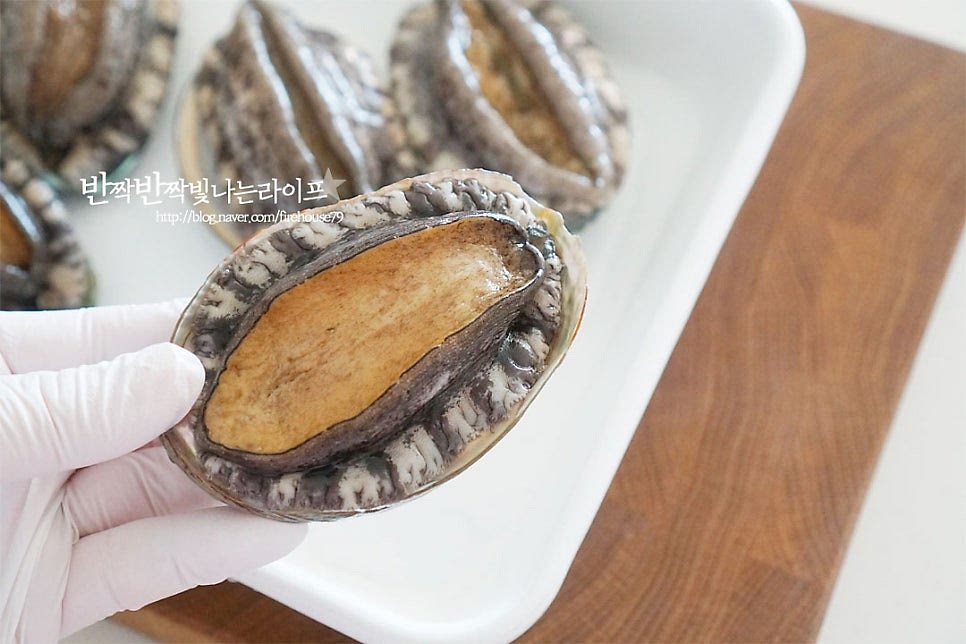 요즘엔 산소포장으로 신선한 활전복을 손쉽게 만나볼 수 있는데요. 크기가 너무 크거나 작지 않은 것으로 1미에 100g 이상 되는 것이 감칠맛도 좋고 적당하게 식감이 있게 요리하기 좋습니다. 조리용 솔로 살짝 문질러가며 세척해 줍니다. 너무 세게 힘을 주면 쫄깃한 식감이 떨어지니 주의해 주세요. 솔로 문지르다 보면 진액이 묻어나니 흐르는 물로 헹구어가며 손질해 주세요. 껍질째 요리하기 때문에 껍데기 부분도 깨끗하게 세척해 줍니다.