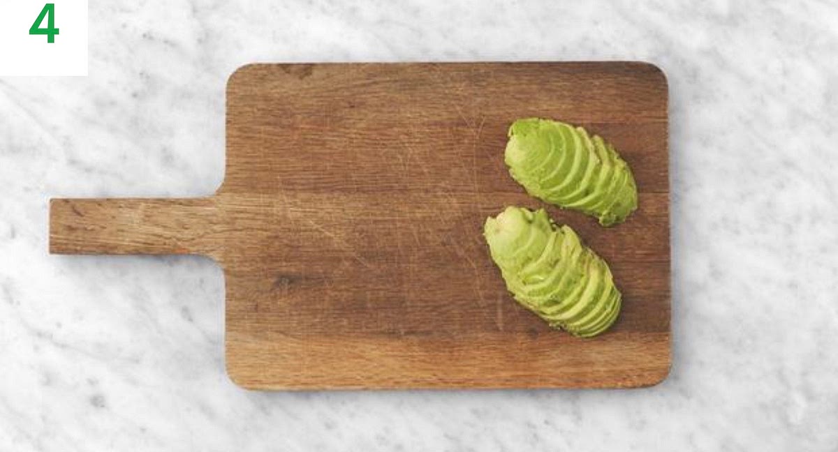 Halve the avocado and remove the stone.
Use a tablespoon to scoop the flesh out onto a board, face-down. Slice into 1cm thick slices.