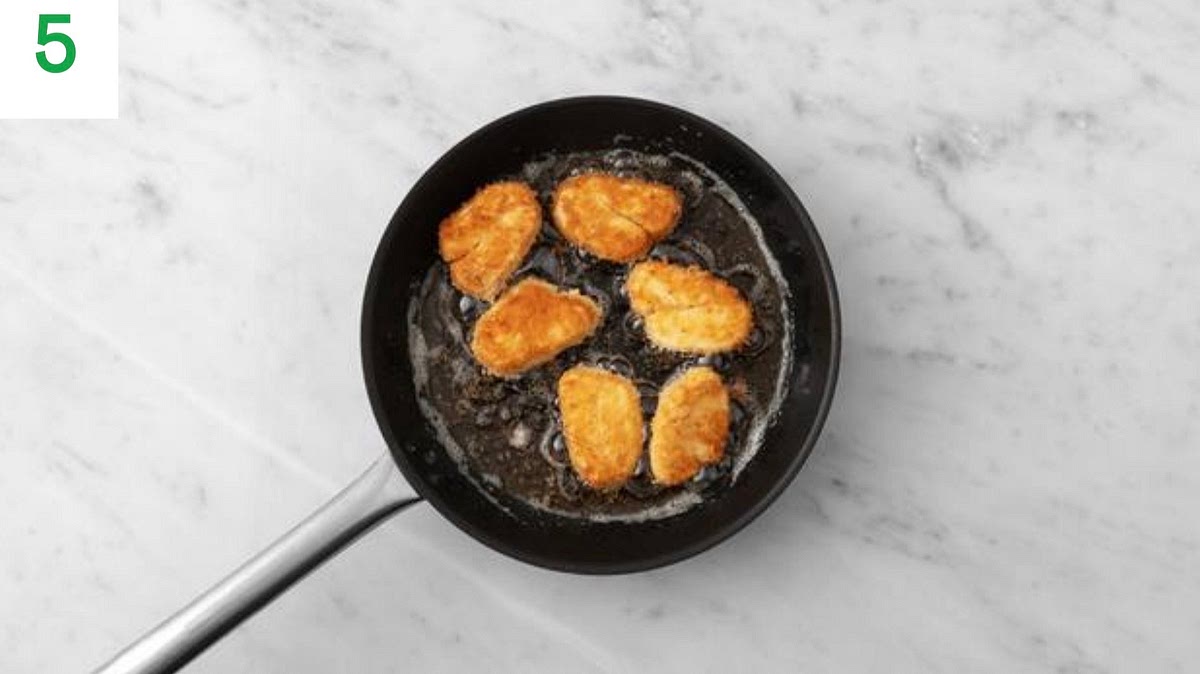 Put a large frying pan on medium-high heat with enough oil to completely coat the bottom of the pan.
TIP: You want the oil to be hot so the halloumi fries properly - heat for 2-3 mins before you add the halloumi.
Once hot, carefully lay in the halloumi, reduce the heat to medium-high and fry until golden-brown, 7-8 mins total. Turn every couple of mins and reduce the heat if needed.
Once golden, transfer to a plate lined with kitchen paper.
Meanwhile, halve the burger buns and pop them into the oven to warm through, 2-3 mins.