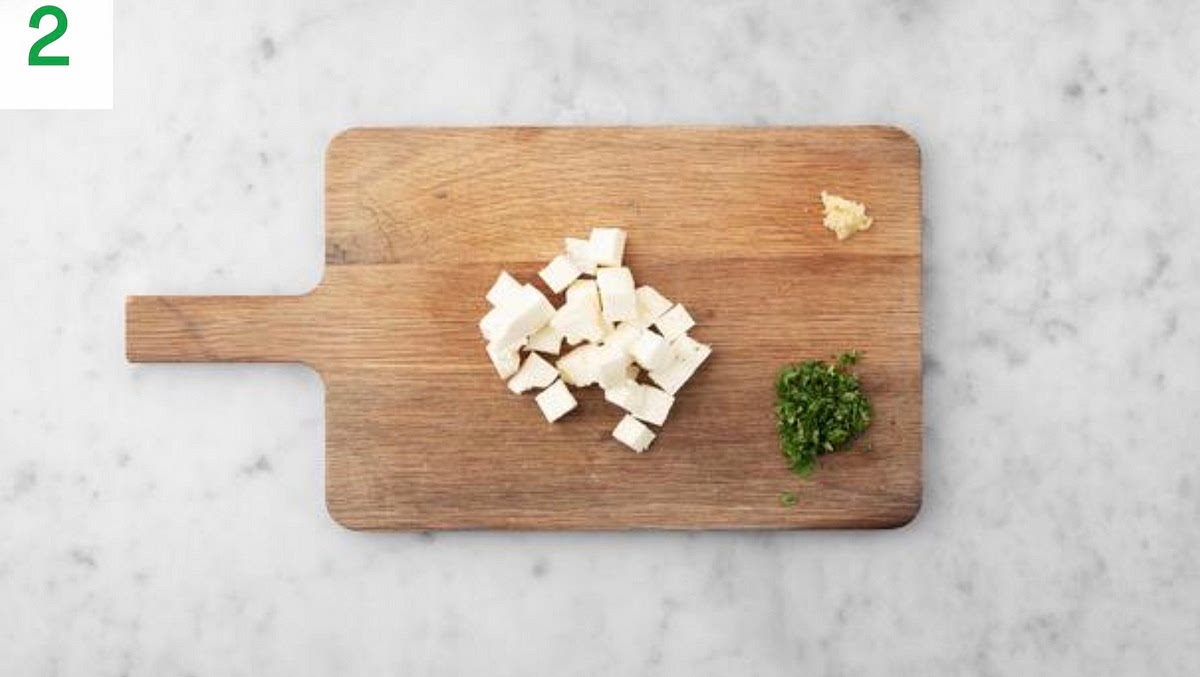 Meanwhile, peel and grate the garlic, or use a garlic press.
Cut the paneer into 2 cm cubes.
Roughly chop the coriander (stalks and all).