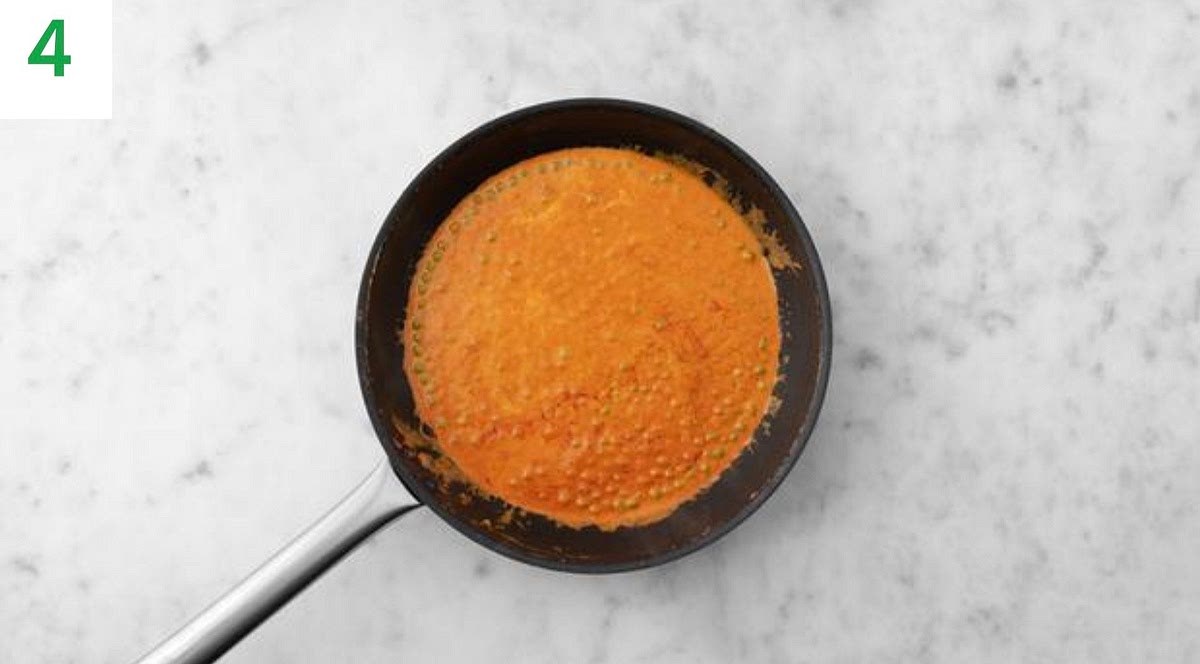 Wipe out the frying pan and return to medium-high heat with a drizzle of oil.
Add the tomato puree, Indian spice mix and half the garlic. Stir -fry until fragrant, 1-2 mins.
Add the vegetable stock paste, crème fraiche, peas, water for the sauce and sugar. Stir to combine, then simmer until the sauce has thickened, 2-3 mins.