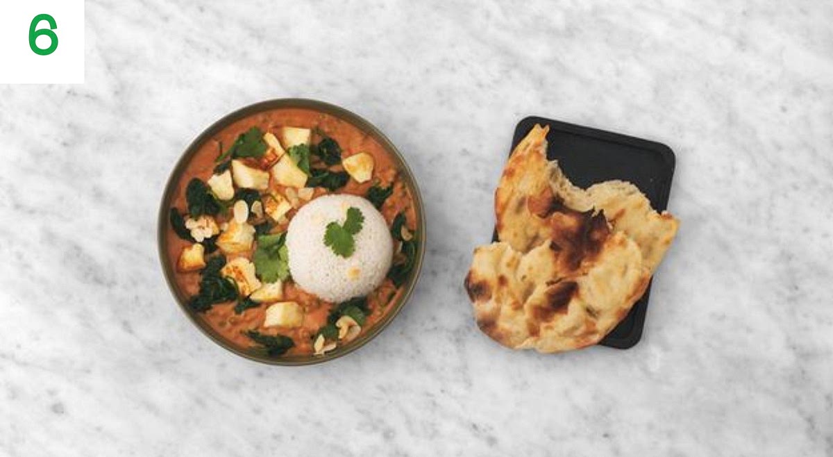 Fluff up the ginger rice with a fork and share between your bowls, then spoon over your ultimate matar saag paneer curry.
Sprinkle over the coriander and flaked almonds to finish. Serve with the garlic naans on the side.