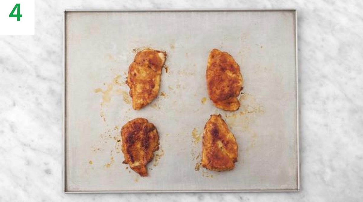 Heat a drizzle of oil in a large frying pan on medium- high heat. Season the chicken with salt and pepper, then lay them into the frying pan.
Cook until browned, 3-4 mins each side. Add the soy sauce for the last min of frying and turn to coat the chicken in the soy.
Meanwhile, trim and thinly slice the spring onion. Peel
and grate the garlic (or use a garlic press).
Transfer the chicken to a baking tray and roast on the top shelf of your oven until the chicken is cooked, 8-10 mins.