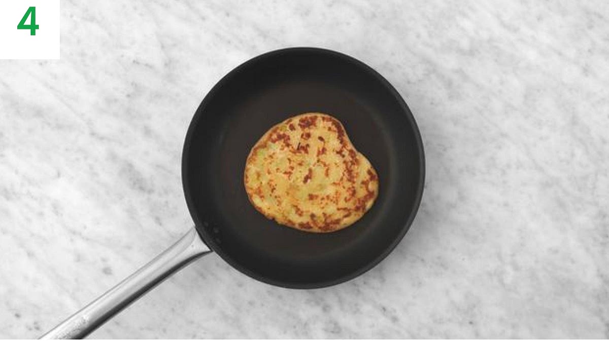Stand a pastry roll up onto one of the cut sides. Using the palm of your hand, press it down to make a flat, swirly disc. Sprinkle over a little flour.
Using a rolling pin, roll the dough into an even circle, approximately 10-15cm in diameter.
Repeat with the remaining pastry rolls.
Heat a large frying pan on medium heat (no oil). Let it heat for 1-2 mins.
Once hot, lay the first pancake into the pan and cook until golden brown, 2-3 mins.