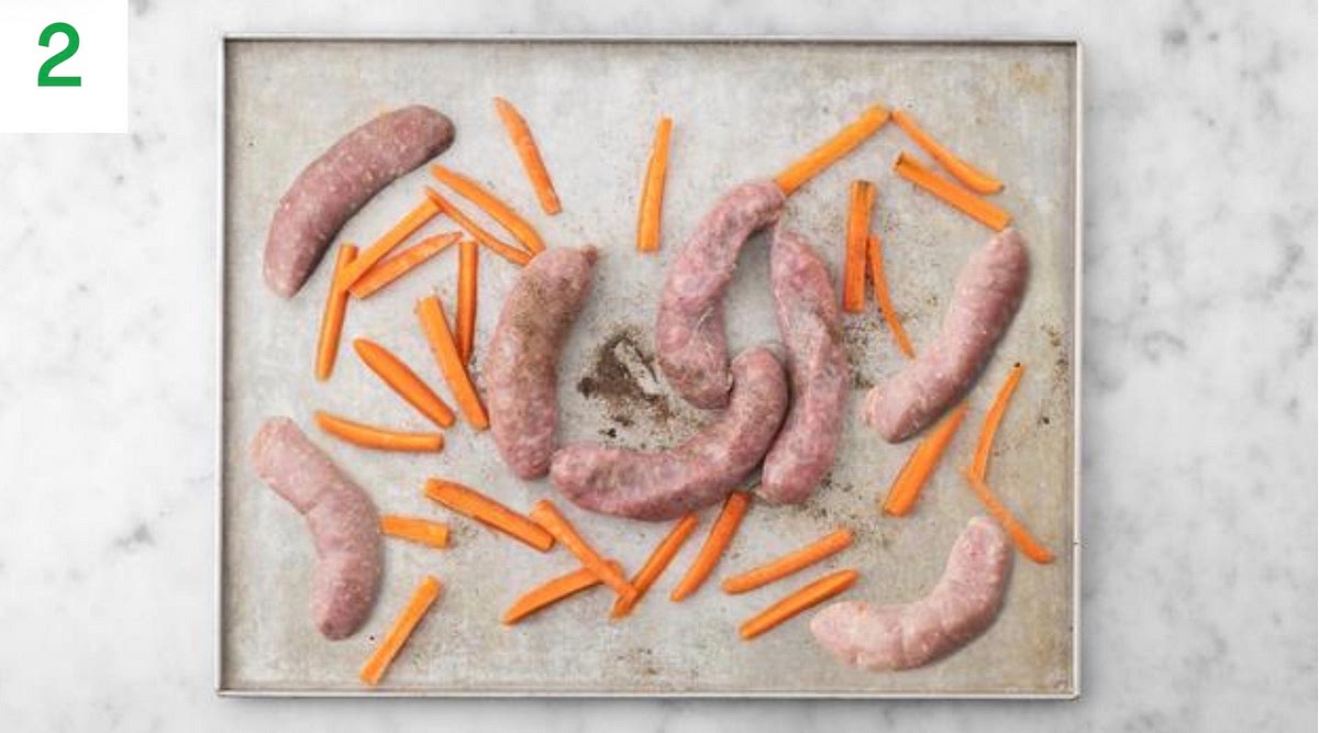 Meanwhile, pop the sausages and carrots onto a large baking tray with a drizzle of oil. Season the carrots with salt and pepper.
When the oven is hot, roast on the top shelf until the carrots are tender and the sausages are browned and cooked through, 18-20 mins. Turn halfway through.
