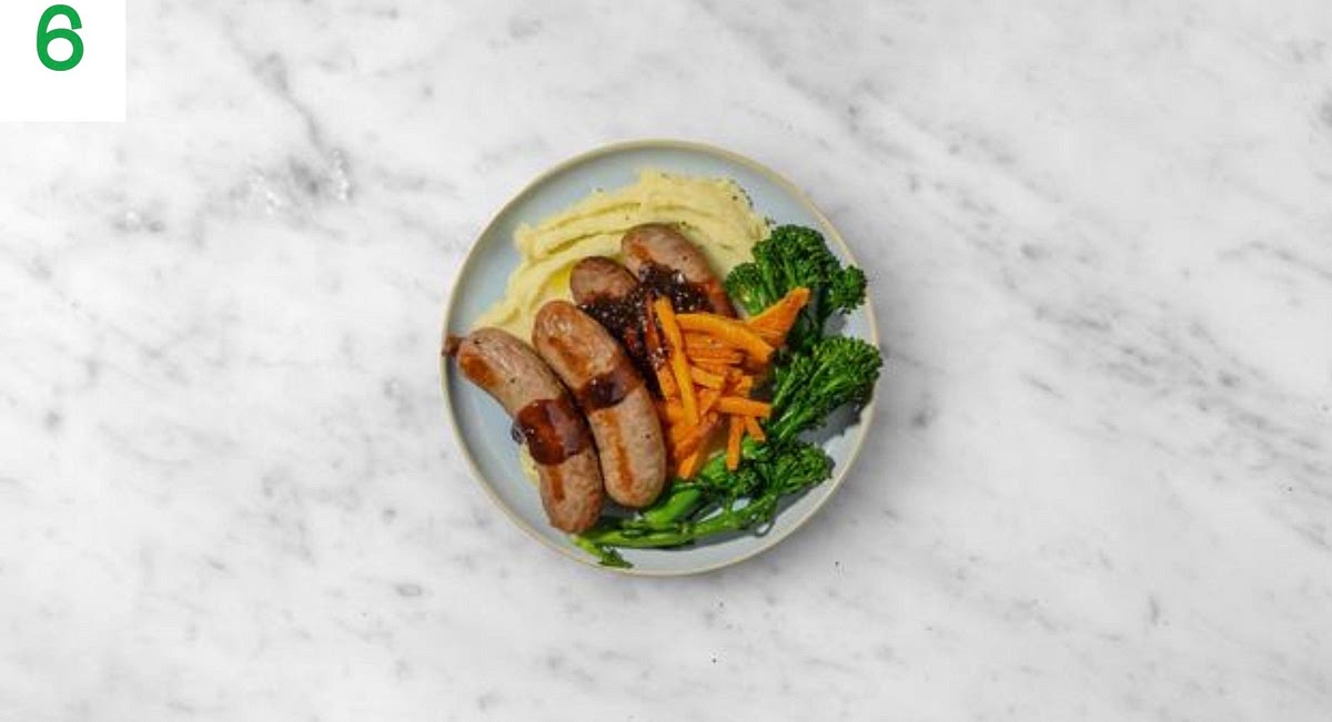 Share the garlic mash between your plates.
Top with the sausages, then pour over the red wine jus (reheat first if needed).
Serve the roasted carrots and Tenderstem® broccoli alongside.