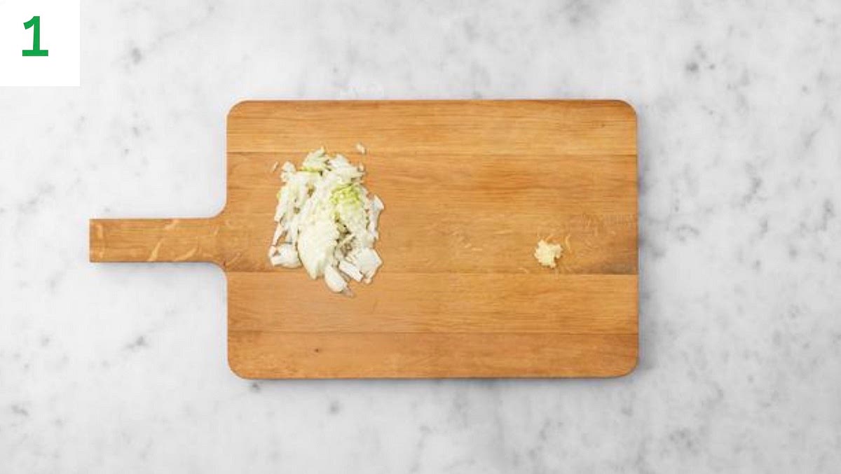 Preheat your oven to 220°C/200°C fan/gas mark 7.
Trim the carrot, then slice into 1.5 cm thick rounds (no need to peel).
Halve, peel and thinly slice the onion. Peel and grate the garlic (or use a garlic press).