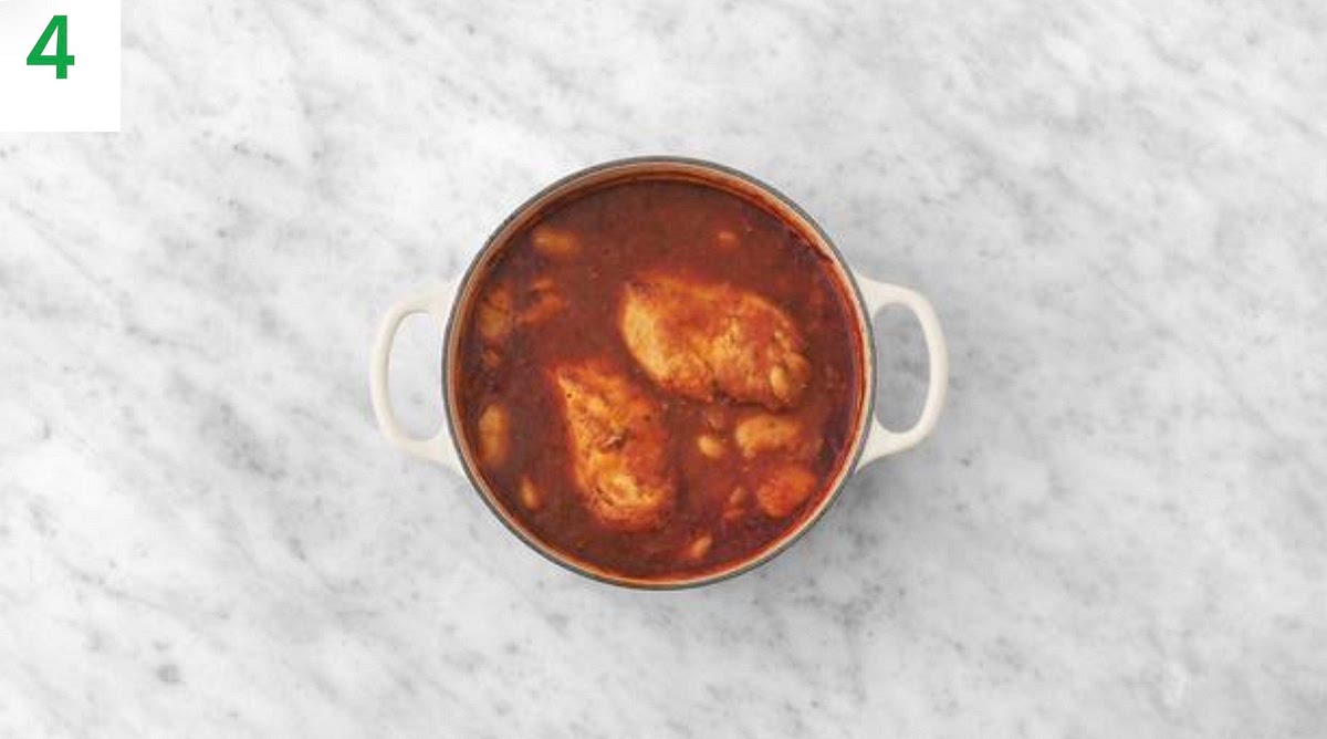 Once boiling, remove from the heat and nestle the chicken breasts into the sauce. Season with salt and pepper.
Cover with a lid or foil and bake on the middle shelf until cooked through, 18-20 mins.