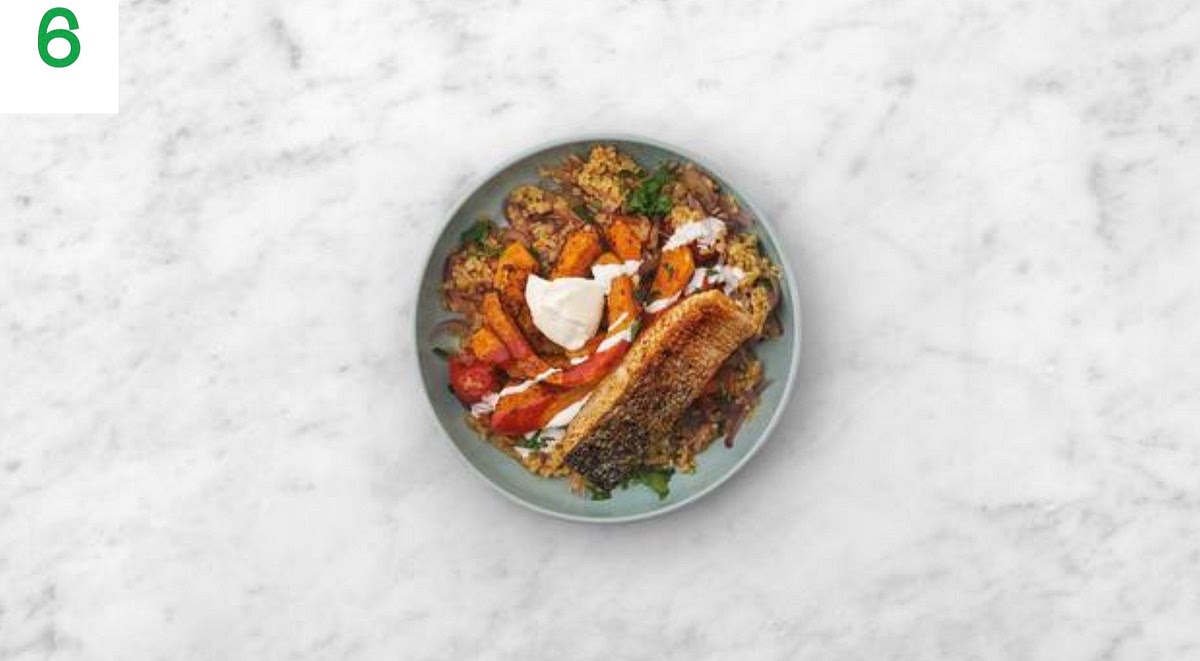 Share the bulgur between your bowls. Top with the salmon fillets and roasted butternut, then drizzle over the honey hot sauce.
Crumble over the Greek style salad cheese. Dollop on the soured cream and sprinkle the remaining coriander to finish.