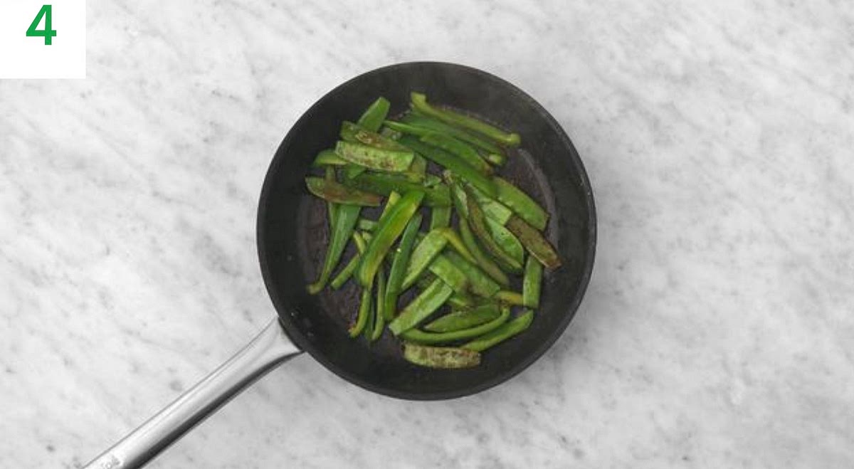 Heat a drizzle of oil in a large frying pan on high heat.
Once hot, add the pepper slices and pea pods, season with salt and pepper and stir-fry until tender, 5-6 mins.
Add the remaining garlic and cook for 1 min more.