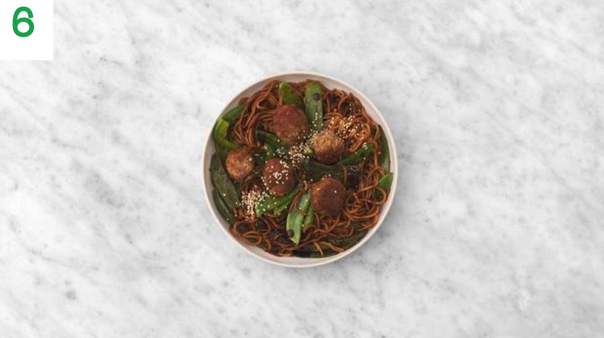 Share the noodles and meatballs between your bowls.
Sprinkle over the sesame seeds to finish.