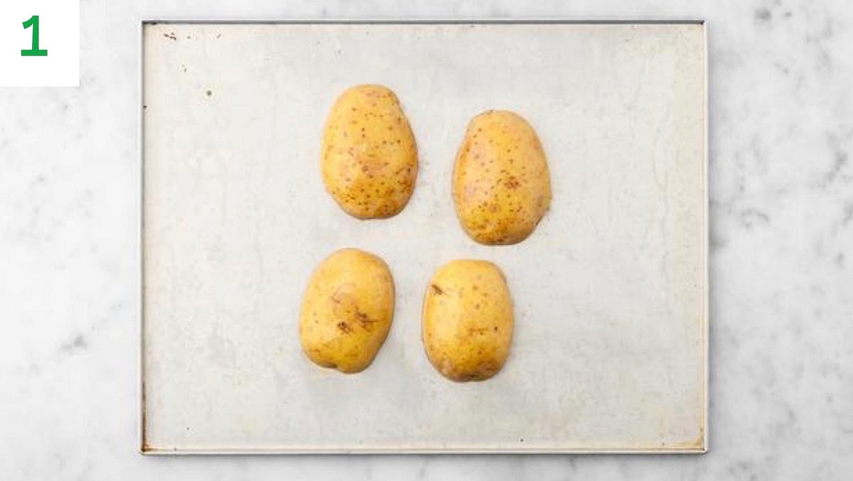 Preheat your oven to 240°C/220°C fan/gas mark 9.
Halve the potatoes lengthways and pop them onto a baking tray.
Drizzle with oil and season with salt and pepper.