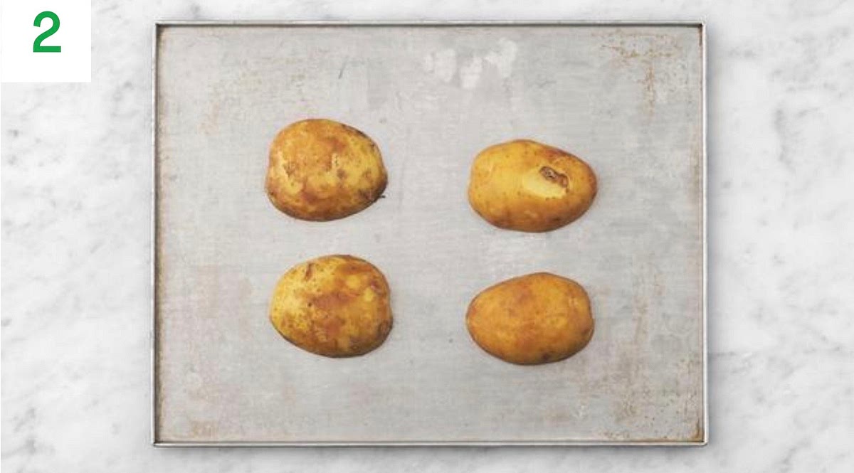 Rub the oil over the potatoes, then lay them cut-side down.
Bake on the top shelf of your oven until tender and a knife slips in easily, 30-40 mins. TIP: Alternatively, if you have a microwave, you can speed things up. Halve the potatoes lengthways, then prick all over with a knife. Rub with a little oil and season with salt. Place cut-side down onto a plate, then microwave on high until tender , 15-18 mins.