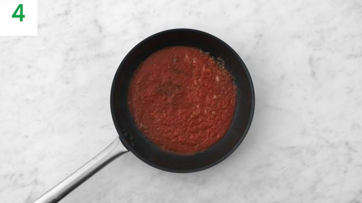 Heat a drizzle of oil in a large frying pan on medium- high heat. Once hot, add the onion and fry until so ened, 4- 5 mins.
Add the dried oregano, harissa paste and garlic. Stir-fry for 1 min.
Stir in the passata, the remaining vegetable stock paste, the sugar and water for the sauce (see pantry for both amounts).
Bring to the boil, then simmer until slightly thickened, 4-5 mins.