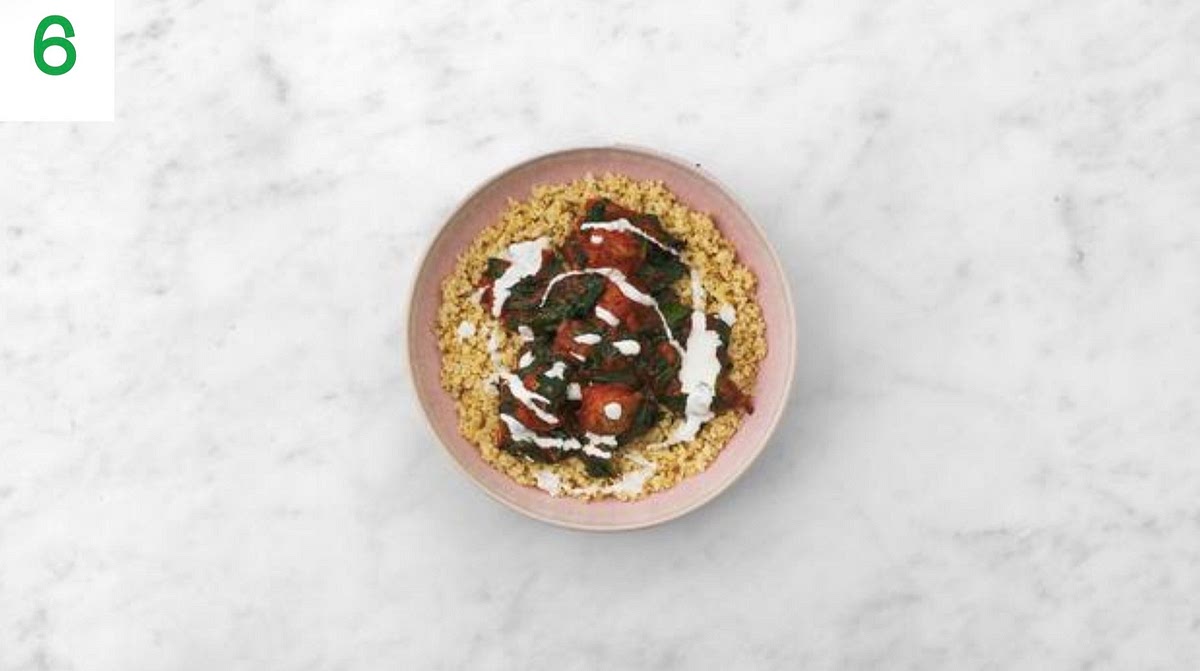 Share the bulgur wheat between your bowls, then top with the falafels and harissa sauce.
Drizzle the yoghurt and crumble over the Greek style salad cheese to finish.