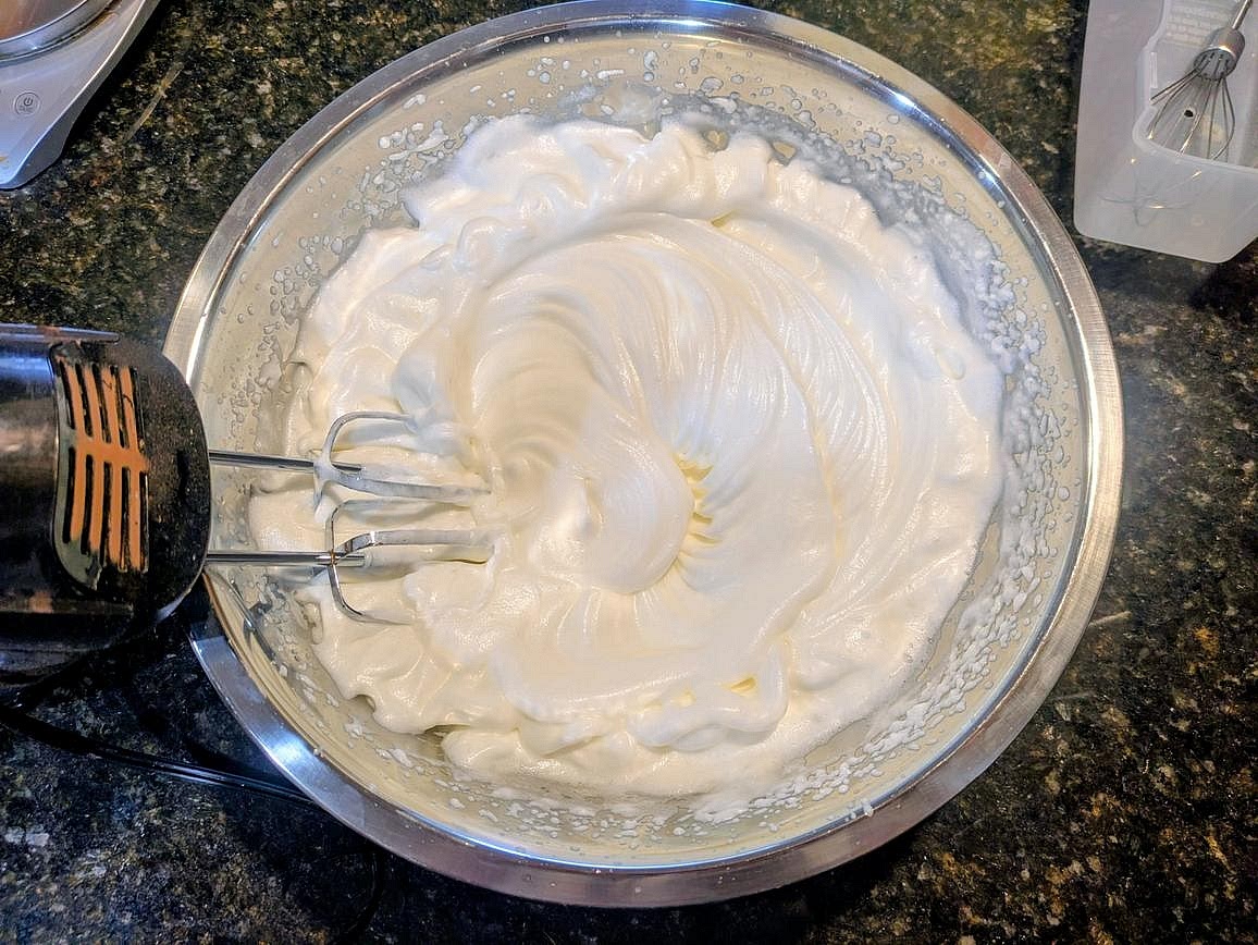 In a very large metal bowl, bean your egg whites with lemon juice until stiff peaks form, at least 5 minutes
