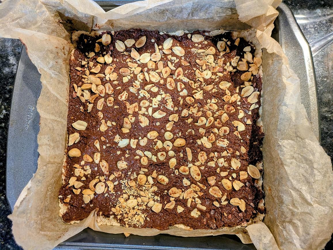 Top with the chopped nuts. Optionally also top with unsweetened shredded coconut flakes and flaky salt. Lightly press the toppings down with a spoon or spatula