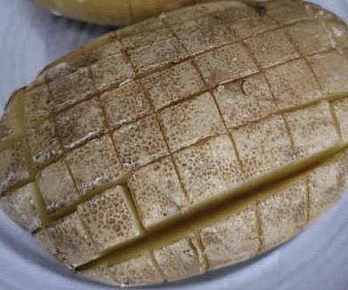 Make cuts in the potato in a grid pattern but DON'T cut it all the way through; leave enough connected at the bottom that it's still all held together.
