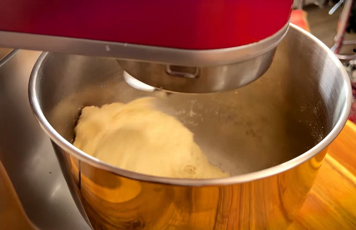 Combine flours, yeast, sugar, and salt in a bowl. Add the oil and gradually pour in the water, mixing until a shaggy dough forms.