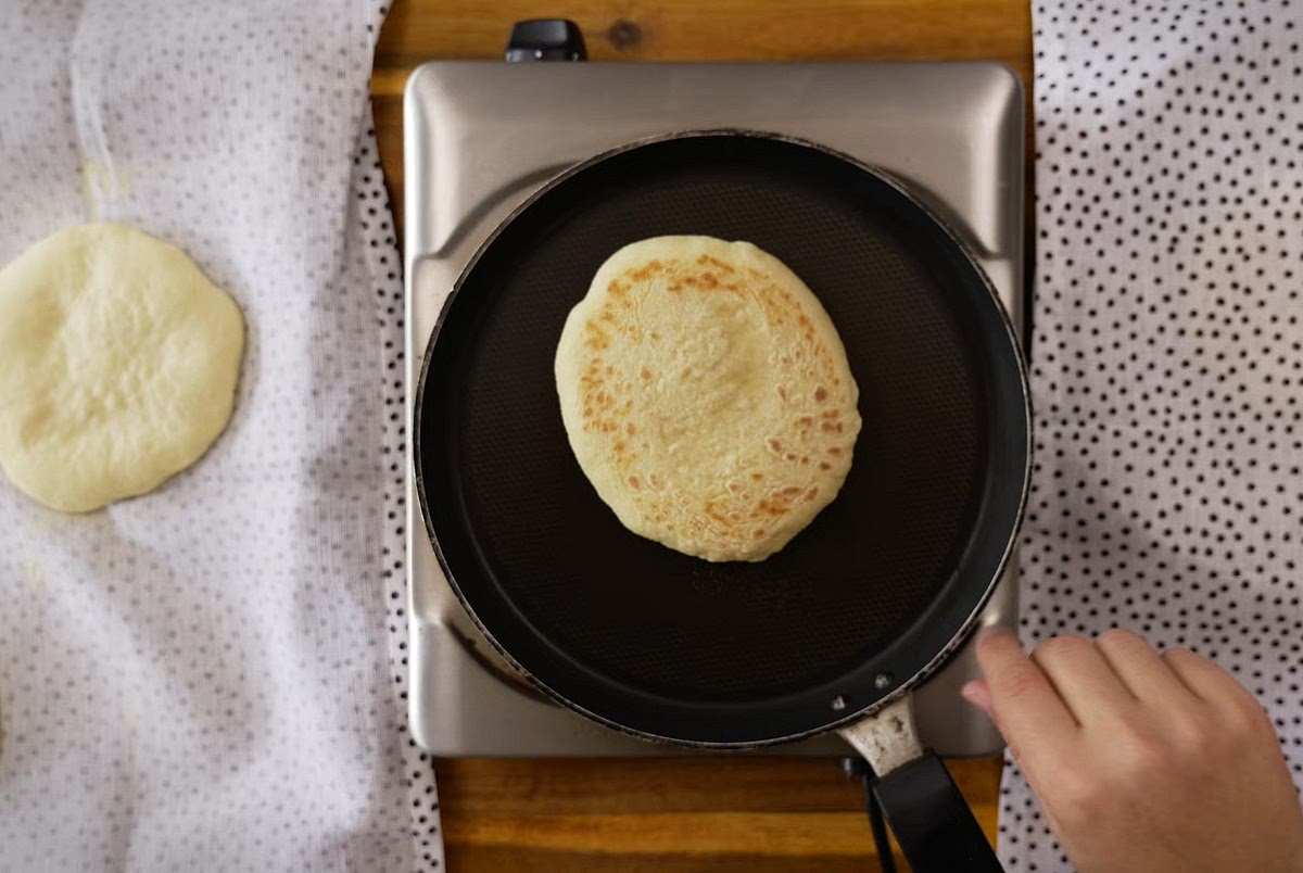 Heat a heavy-bottomed skillet or cast iron pan over medium heat. Do not use oil in the pan. Place the discs in the pan and cook for 1–2 minutes per side, flipping frequently, until they puff up and develop golden-brown spots.