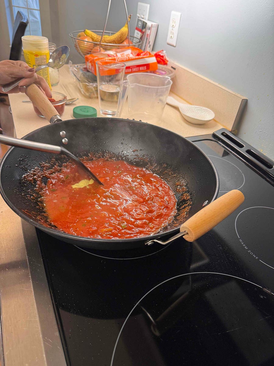 Boil spaghetti per box instructions and drain saving the pasta water. Dice onion and green pepper. Half the olives. On medium high heat sauté the onion, garlic, and olives for 3 minutes.
Add butter, tomato paste, pasta water, garlic, chicken bullion, and sazón. Season with Parmesan cheese to taste as desired.