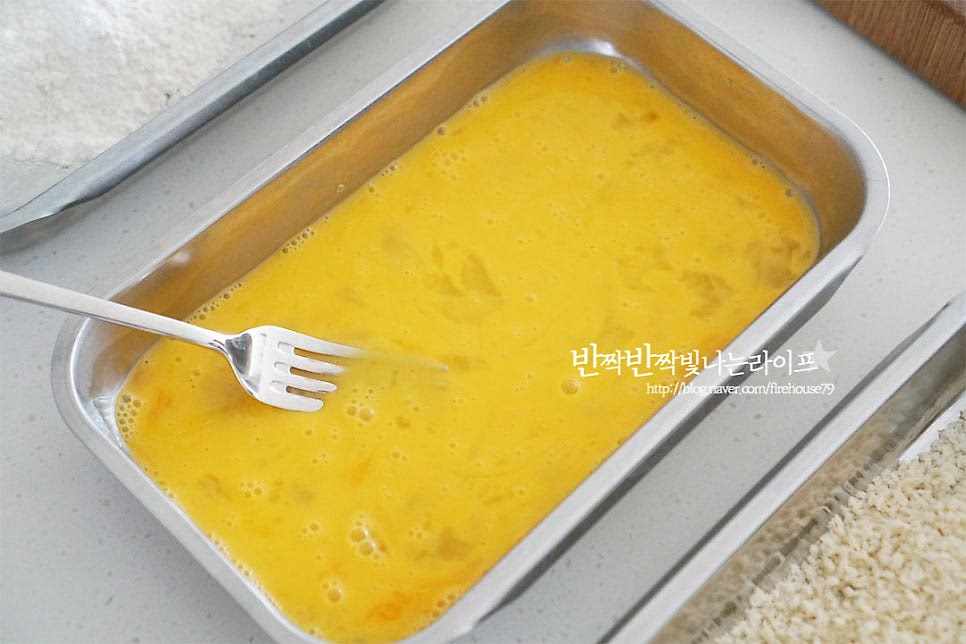 돈까스만들기 기본 재료는 밀가루-계란-빵가루입니다. 달걀은 부드럽게 풀어서 준비해 줍니다. 각각 밀가루, 달걀, 빵가루 순으로 손질하기 쉽도록 담아 준비해 주세요. 등심에 밀가루를 묻혀줍니다. 뭉치지 않게 살짝 털어가며 얇게 입혀주세요. 앞뒤로 돌려가며 달걀물을 입힌 뒤 빵가루를 꼼꼼하게 입혀줍니다. 하나씩 반복하여 튀김옷을 입혀주세요.