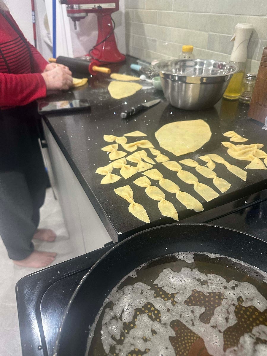 Roll out dough (thinly) with rolling pin and make bow like shapes. Oil should be on low. Fry dough prices until very very lightly fried. Remove from oil and cover with icing sugar and pistachio.