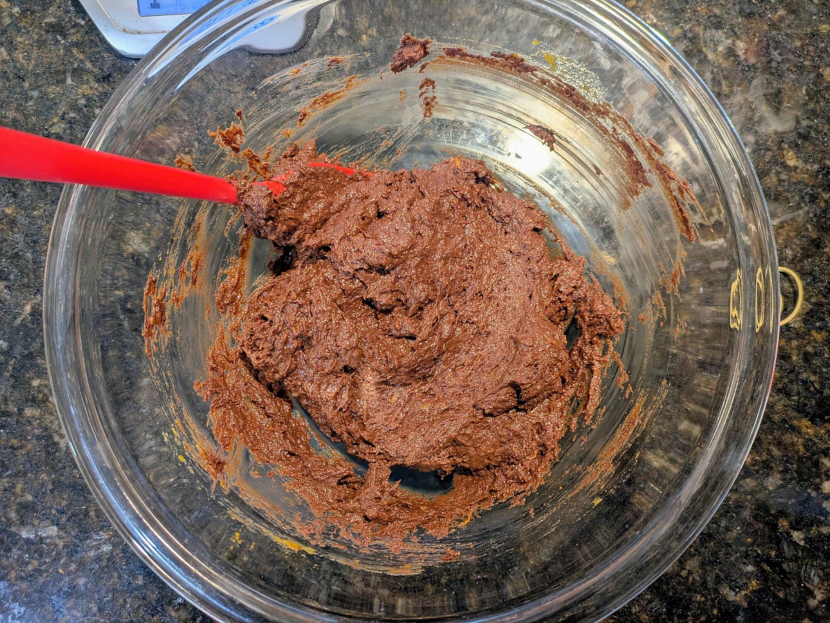 Pour the melted chocolate into the large bowl, and mix until fully combined. Fold in most of the chocolate chips, reserving some for the top
