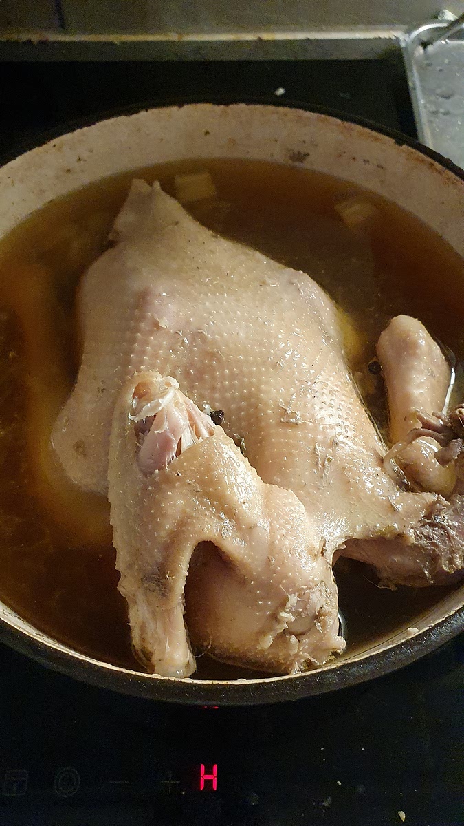 Cook for at least 4 hours or until the meat falls off the bone. You can see in this picture that the bone of the wing is visible without me even cutting into it.
At this point the hen is done, and the water has turned into broth. You can use the bone for cooking, art, or (if you have a garden) crush it into powder and mix it into the soil.
